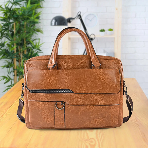 Brown leather briefcase on a wooden surface with a plant and lamp in the background