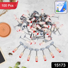Pile of upholstery nails with a small container on a textured surface