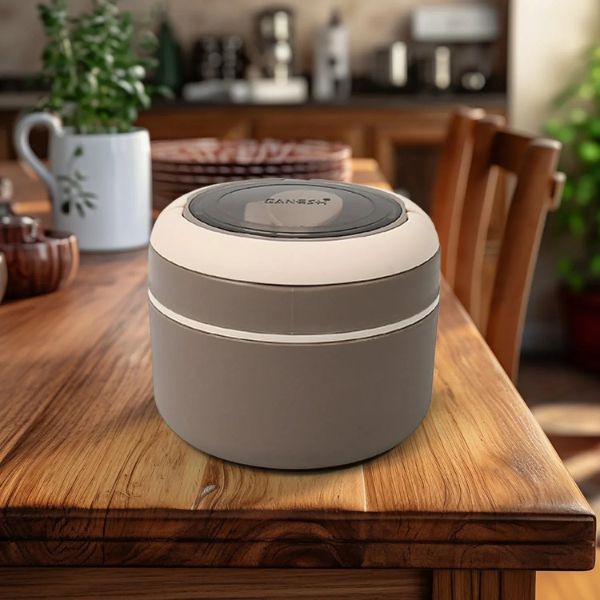 Round beige container with black lid on a wooden table in a kitchen setting