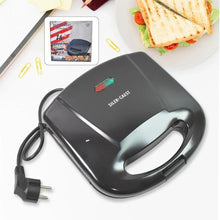 Black sandwich maker with a plug on a white background, showing a plate of grilled sandwiches.