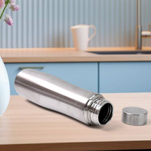 Silver insulated bottle on a kitchen counter with a blurred background