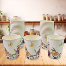 Stacks of paper cups with floral designs on a wooden surface.