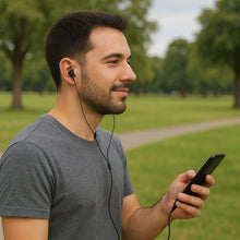 Man listening to music with earphones and a smartphone in a park
