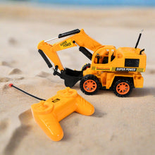 Toy excavator with remote control on a sandy surface