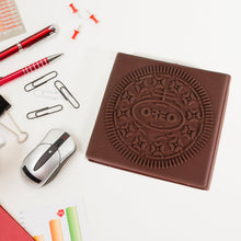 Chocolate Oreo cookie on a desk with office supplies