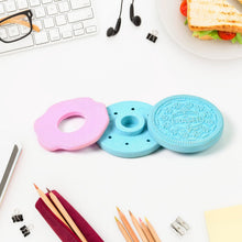 Three colorful Oreo-shaped desk organizers on a desk with stationery items.