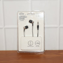 In-ear headphones in packaging on a wooden surface