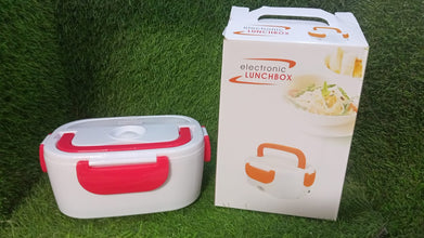 Lunch box with red accents and its packaging on a grass background