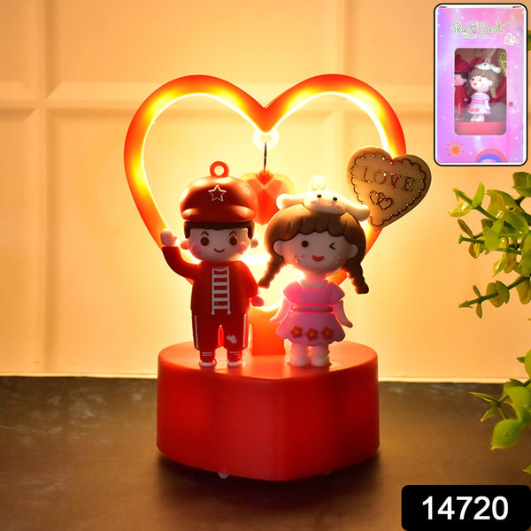 Decorative night light with cartoon characters and heart-shaped LED light on a wooden surface.