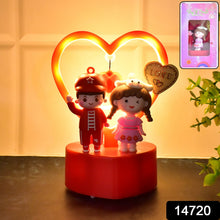 Decorative night light with cartoon characters and heart-shaped LED light on a wooden surface.