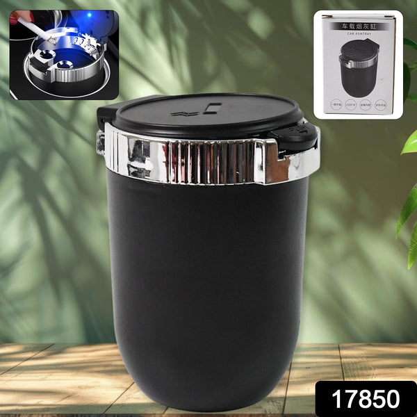 Black and silver container with a lid on a wooden surface with green leaves in the background
