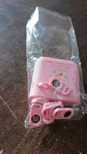 Pink hair tie set in clear packaging on a wooden surface