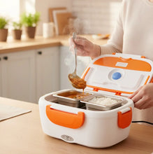 Person using an electric lunch box with food in a kitchen setting