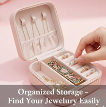 Pink jewelry box with jewelry items on a pink background