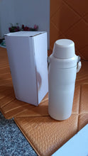 White thermos bottle on a textured surface with a white box in the background
