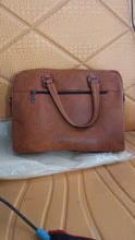 Brown leather briefcase on a textured beige surface