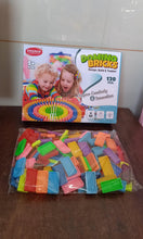 Colorful Domino Bricks set with packaging on a wooden surface