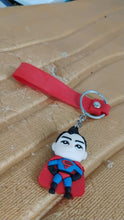 Keychain with cartoon character on a red strap on a wooden surface