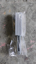 Small metal tool with a sanding block on a textured surface