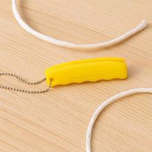 Yellow tool with a chain on a wooden surface