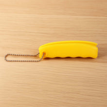 Yellow tool with a chain on a wooden surface