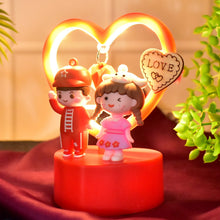 Decorative night light with cartoon characters and a heart-shaped light on a red base.