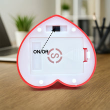 Heart-shaped device with 'ON/OFF' switch on a wooden surface