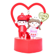 Decorative figurine of a boy and girl with a heart-shaped background on a white background