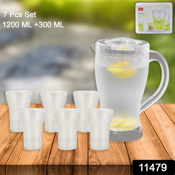 Clear glass pitcher and cups with lemon slices on a wooden surface, set 