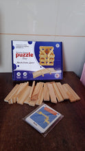 Wooden puzzle pieces and packaging on a table with a tiled wall background