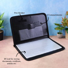 Black document holder with pen holder and compartments on a pink surface with plants in the background